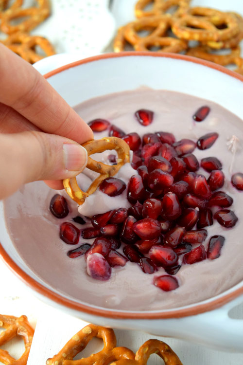 Pretzel dipped into Whipped Goat Cheese & Grape Jelly Dip