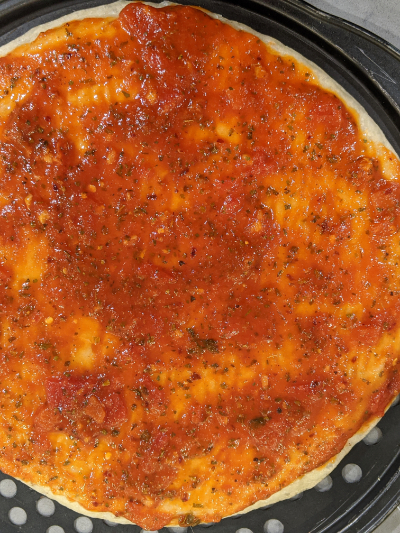 homemade thick crispy bottom pan pizza sauce on crust