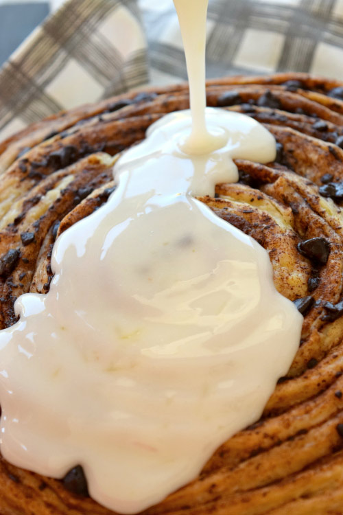 Pouring Orange Icing on Chocolate Cinnamon Roll Cake.