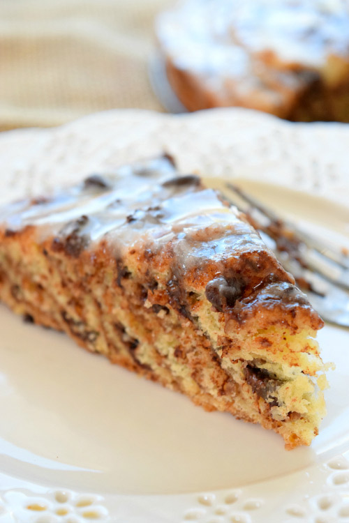 Slice of Chocolate Cinnamon Roll Cake with Orange Icing.