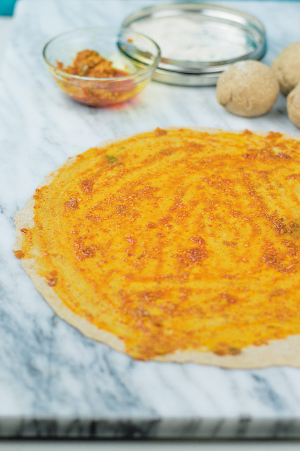 adding achaar on rolled out dough for lachha paratha