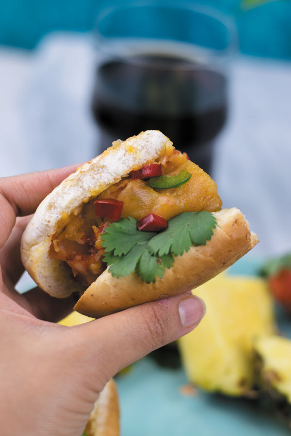 shot of cheesy french fries-sandwich in hand