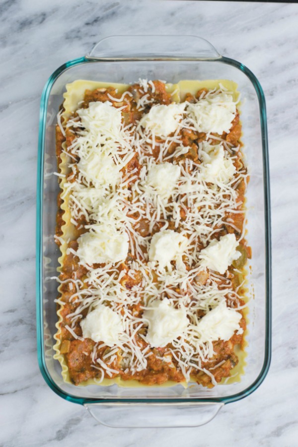 spreading shredded cheese for easy vegetarian lasagna