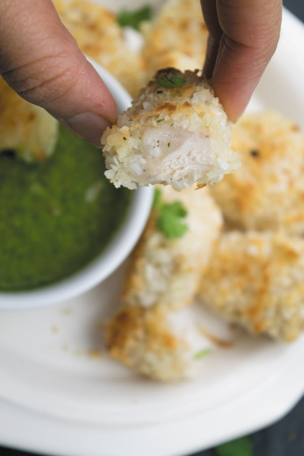 Crunchy Baked Coconut Chicken Bites - Crunchy baked coconut chicken, slightly on the sweeter side served with a spicy cilantro dipping sauce. A great way to make a delicious quick dinner!