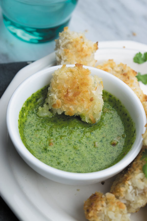 Crunchy Baked Coconut Chicken Bites - Crunchy baked coconut chicken, slightly on the sweeter side served with a spicy cilantro dipping sauce. A great way to make a delicious quick dinner!