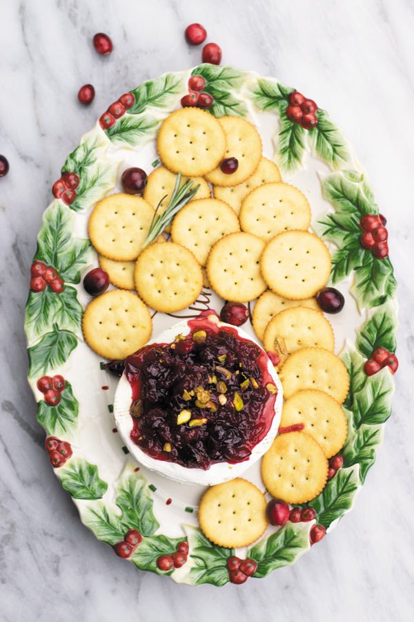 Baked brie with orange cranberry sauce - Delicious & simple holiday appetizer. Baked brie served with a simple yet beautifully flavored orange cranberry sauce! I can't stop eating this.