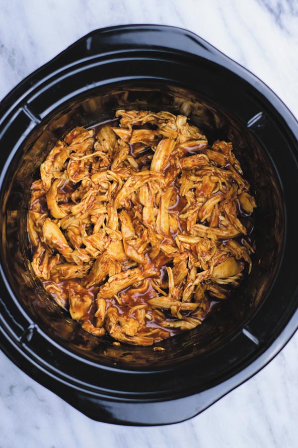 Slow Cooker BBQ Shredded Chicken - just 3 ingredients are all you need to make this delicious BBQ shredded chicken! Great in sandwiches, tacos, burritos or plain! I always make a big batch and freeze the extras to have on hand for quick dinners!