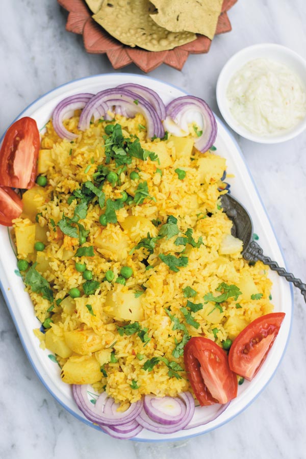 slow cooker spiced vegetable rice - delicious eaten plain or served as a side, this one pot meal comes together in slow cooker! Spiced rice with peas and potatoes makes for a meal loved by all! Leftovers are great for next day lunch with grilled chicken or eaten plain with yogurt & pickle!