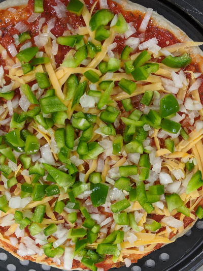 homemade thick crispy bottom pan pizza veggies before baking